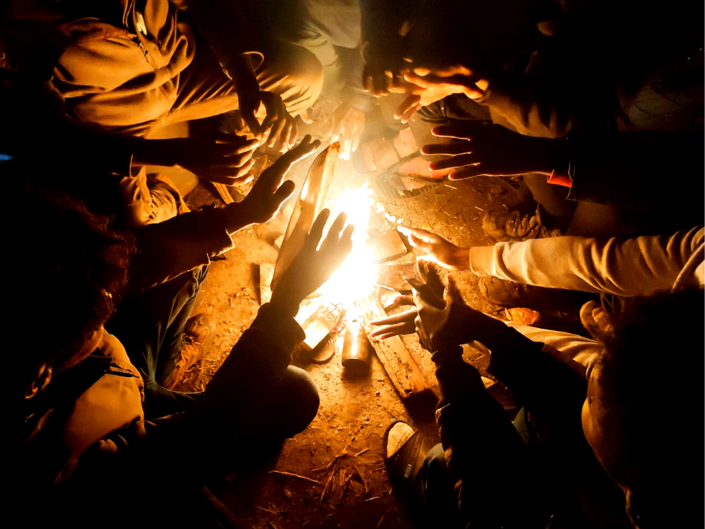Des personnes se réchauffent autours d'un feu - L'auberge des Migrants